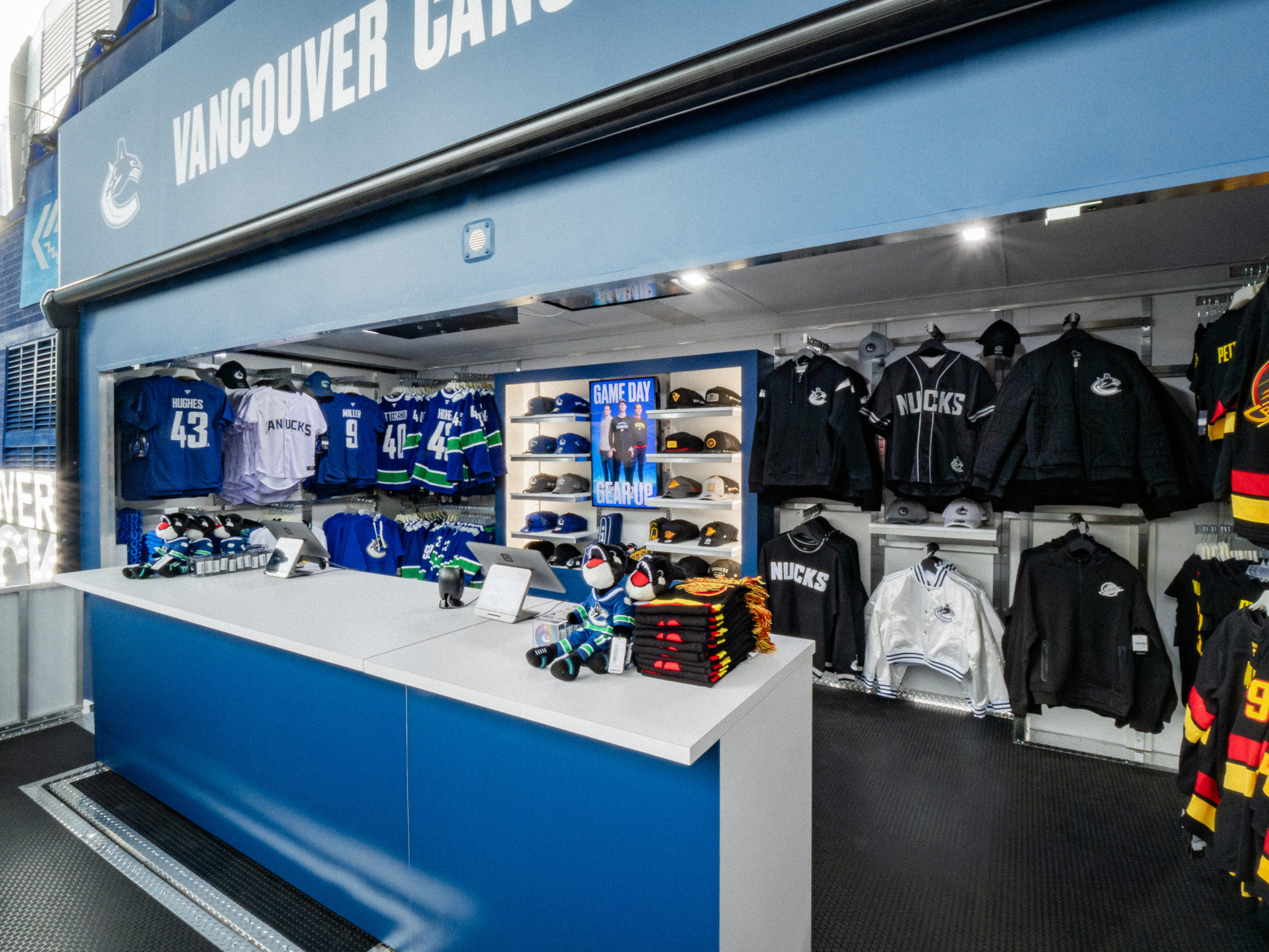 Vancouver Canucks mobile retail trailer interior with organized zone-based merchandise layout