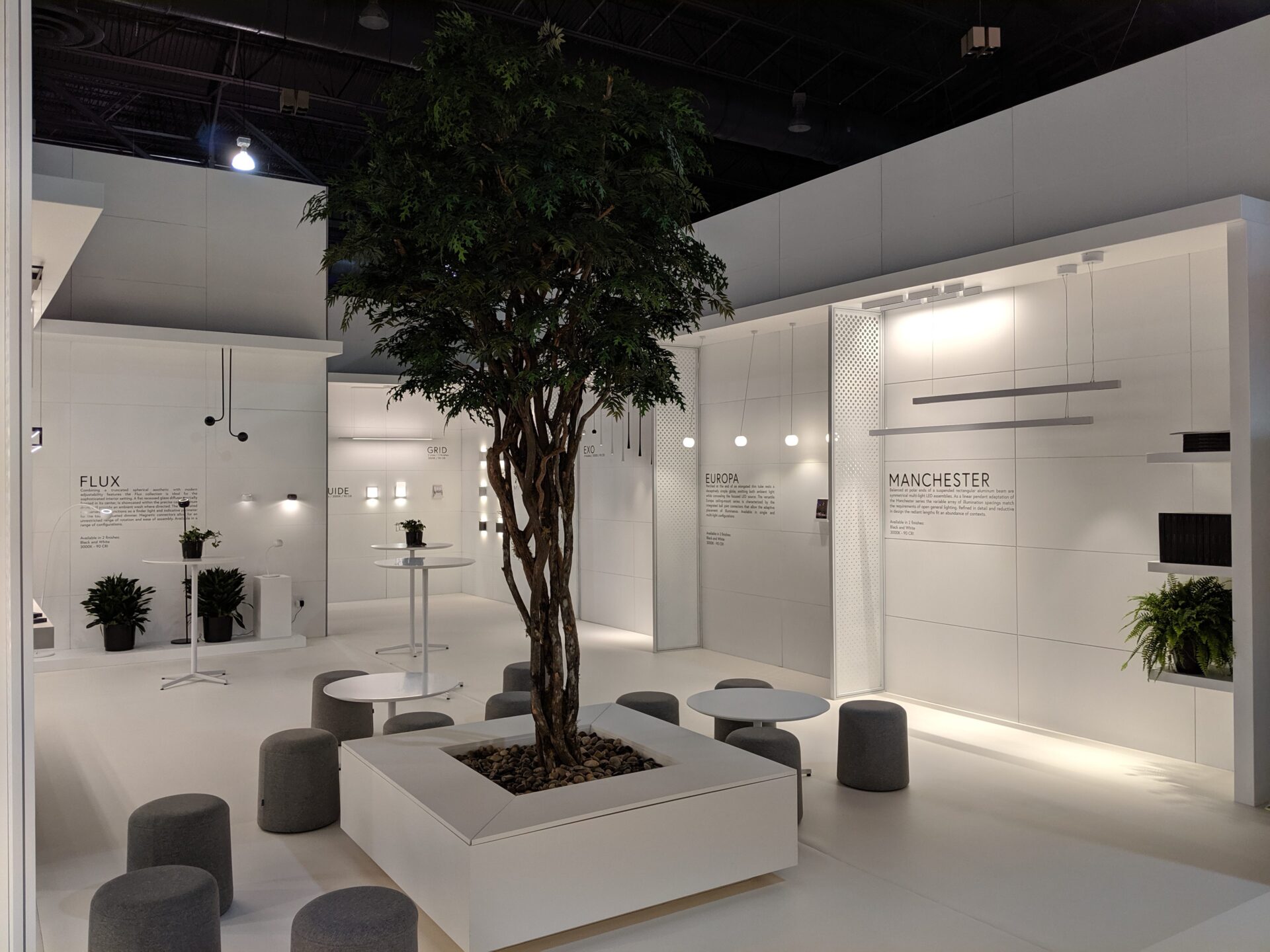 Kuzco trade show booth with greenery and upscale fabric seeting